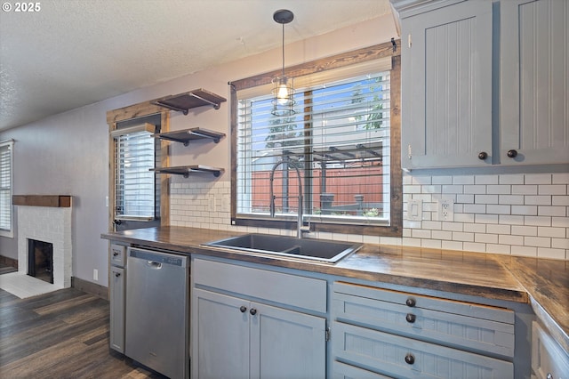 20694 SW Parker Ct, Beaverton, OR 97078 - kitchen featuring dishwasher, butcher block counters, dark wood-style flooring, a brick fireplace, and tasteful backsplash