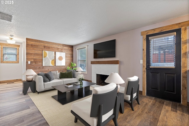 20694 SW Parker Ct, Beaverton, OR 97078 - living area featuring wooden walls, plenty of natural light, wood finished floors, a textured ceiling, and a brick fireplace