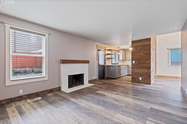 20694 SW Parker Ct, Beaverton, OR 97078 - unfurnished living room with dark wood-style flooring, a fireplace, plenty of natural light, and a textured ceiling