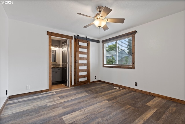 20694 SW Parker Ct, Beaverton, OR 97078 - spare room featuring a barn door, dark wood-style floors, and a ceiling fan