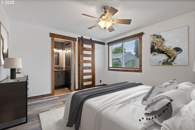 20694 SW Parker Ct, Beaverton, OR 97078 - bedroom featuring a barn door, wood finished floors, ceiling fan, and ensuite bath