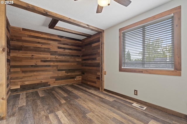 20694 SW Parker Ct, Beaverton, OR 97078 - spare room featuring ceiling fan, dark wood-style floors, wooden walls, and beamed ceiling