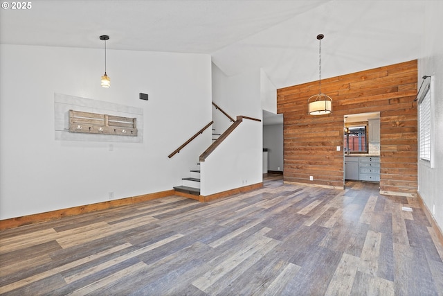 20694 SW Parker Ct, Beaverton, OR 97078 - unfurnished living room featuring wooden walls, wood finished floors, stairway, and high vaulted ceiling