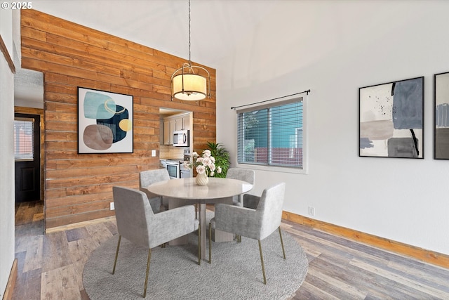 20694 SW Parker Ct, Beaverton, OR 97078 - dining room with wooden walls, wood finished floors, and a towering ceiling