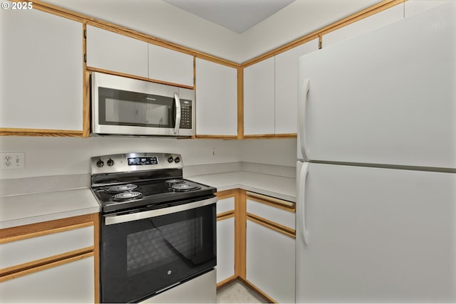 3617 Westleigh St, Eugene, OR 97405 - kitchen with freestanding refrigerator, range with electric stovetop, stainless steel microwave, light countertops, and white cabinets