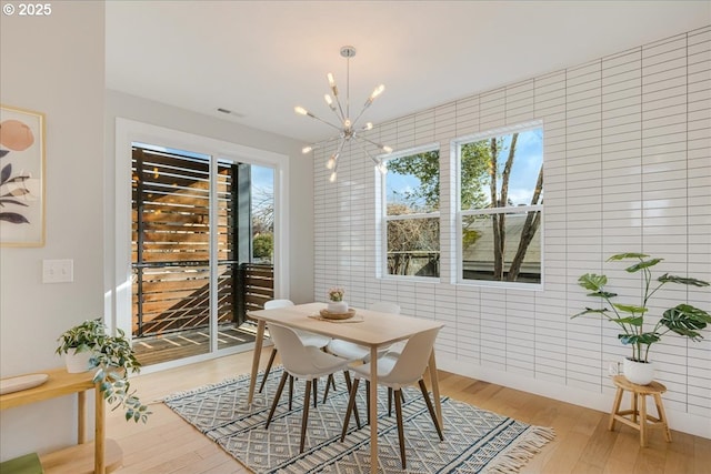 dining room featuring light wood finished floors and a chandelier