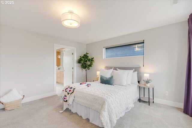 carpeted bedroom featuring baseboards and ensuite bathroom
