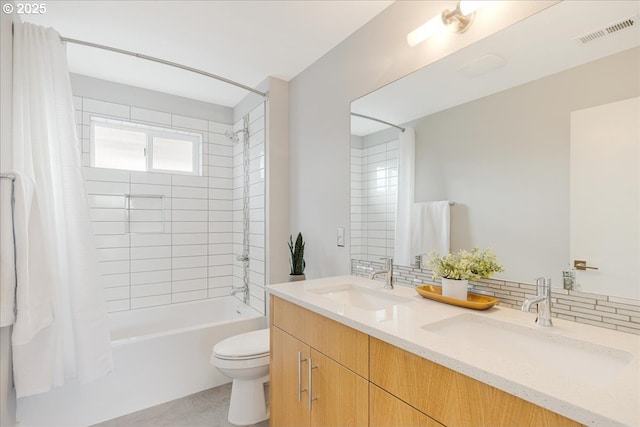 bathroom featuring visible vents, a sink, shower / bath combo with shower curtain, and toilet