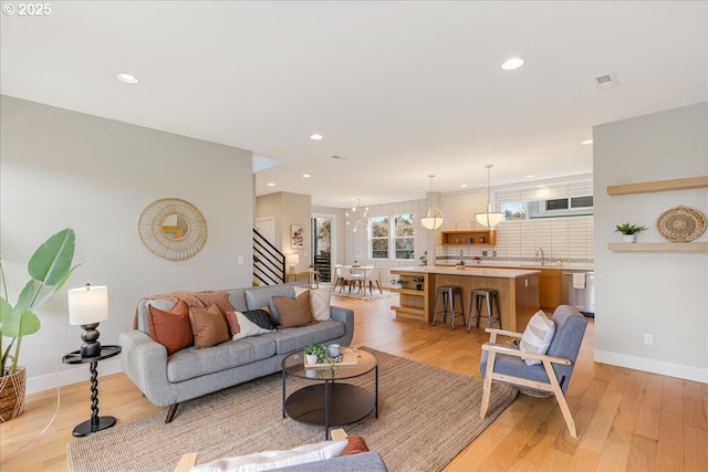 living area featuring recessed lighting, visible vents, and light wood-type flooring