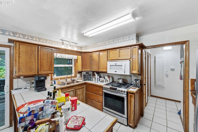 808 E 14th St, Coquille, OR 97423 - kitchen with gas range, white microwave, a sink, tile countertops, and brown cabinets