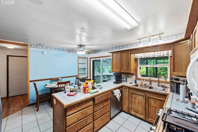 808 E 14th St, Coquille, OR 97423 - kitchen with stainless steel dishwasher, tile countertops, a peninsula, brown cabinets, and a sink