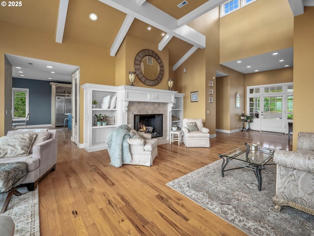 9320 NW Skyview Ct, Portland, OR 97231 - living area featuring a towering ceiling, wood finished floors, baseboards, beamed ceiling, and a fireplace