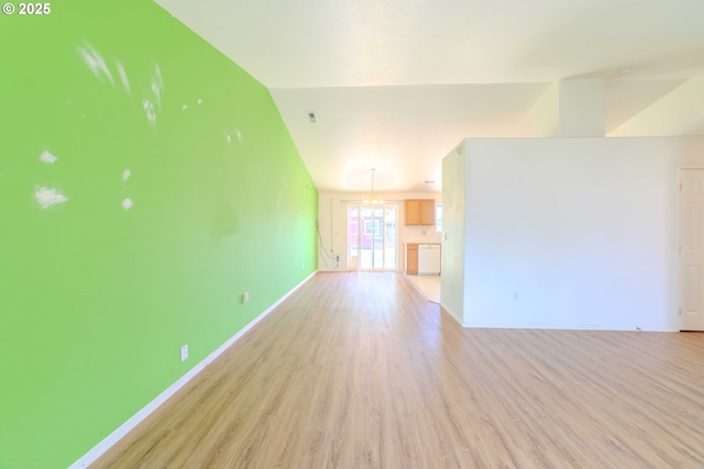 unfurnished living room with baseboards, light wood-style flooring, and vaulted ceiling