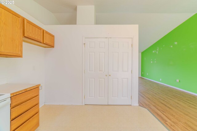 kitchen with baseboards, light countertops, and lofted ceiling