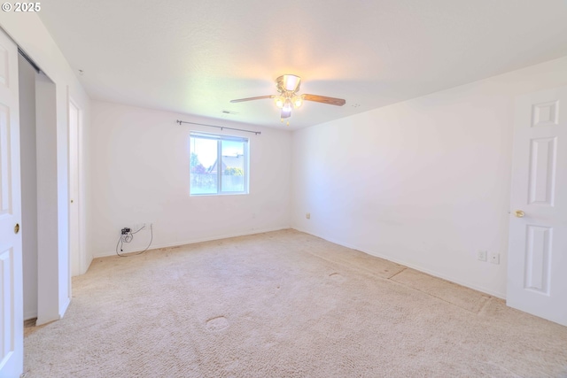 empty room featuring carpet floors and a ceiling fan