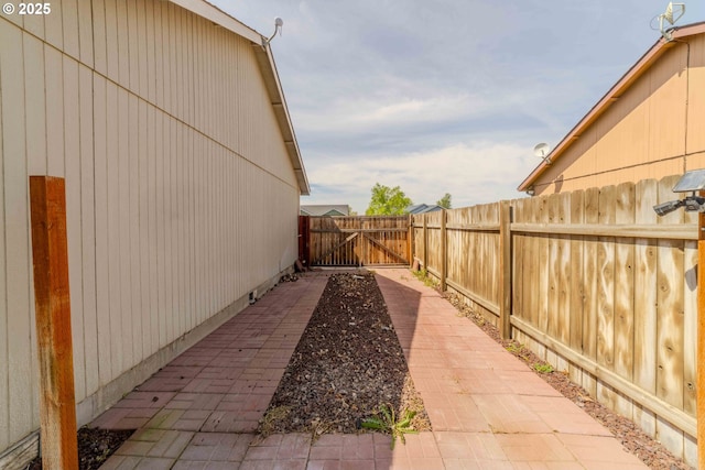 view of home's exterior with a gate, a patio area, and fence