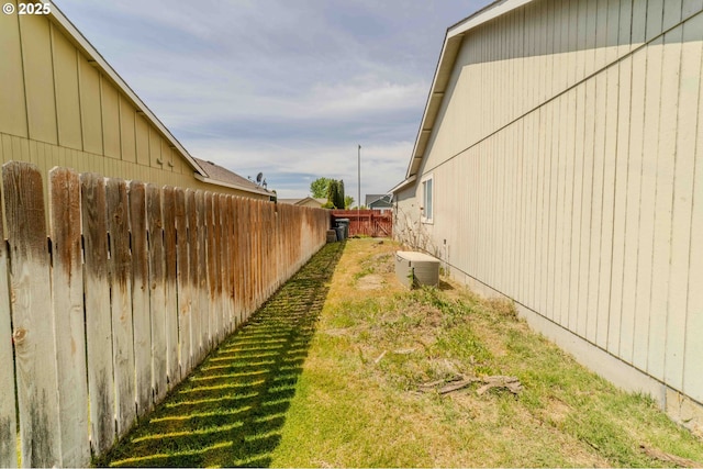 view of yard with fence and central AC