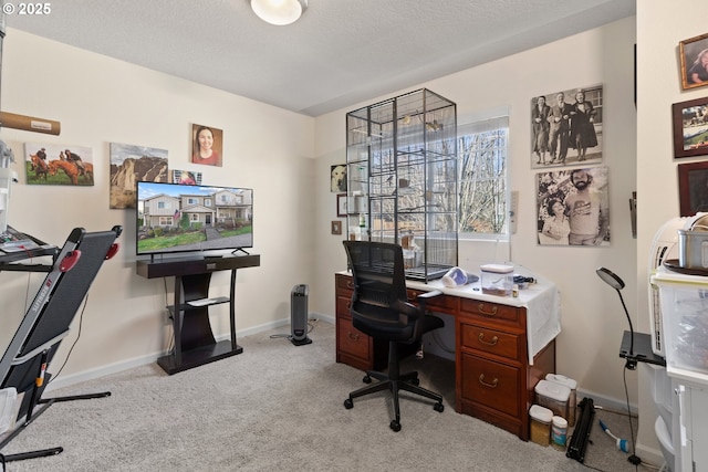 carpeted home office featuring a textured ceiling and baseboards