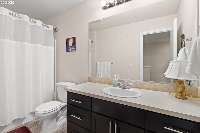 bathroom with shower / bathtub combination with curtain, vanity, and toilet