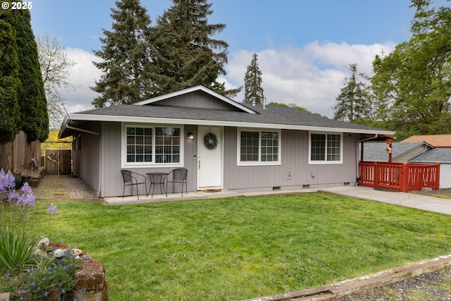 view of front facade with crawl space, fence, roof with shingles, and a front lawn