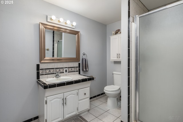 bathroom featuring decorative backsplash, a stall shower, vanity, tile patterned floors, and toilet