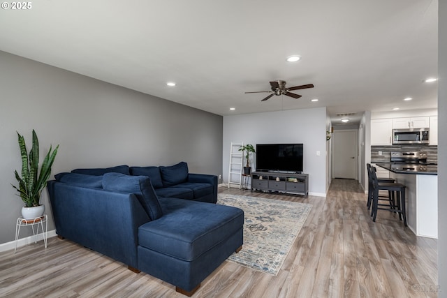 living area featuring recessed lighting, baseboards, ceiling fan, and light wood-type flooring