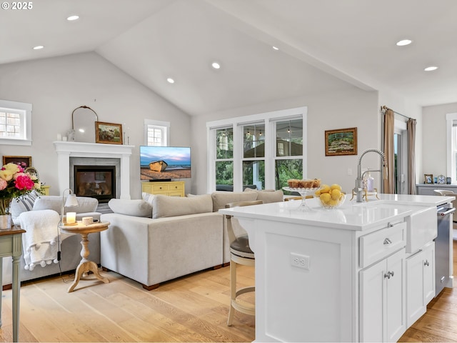 196 Dylan Ct, Gearhart, OR 97138 - living room featuring vaulted ceiling, light wood-style floors, recessed lighting, and a glass covered fireplace
