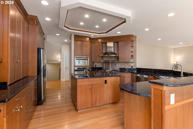 16215 SE Rivershore Dr, Vancouver, WA 98683 - kitchen featuring wall chimney range hood, stainless steel appliances, a sink, light wood-style floors, and a textured ceiling