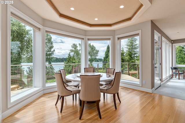 16215 SE Rivershore Dr, Vancouver, WA 98683 - dining room featuring a tray ceiling, plenty of natural light, light wood-type flooring, and a water view