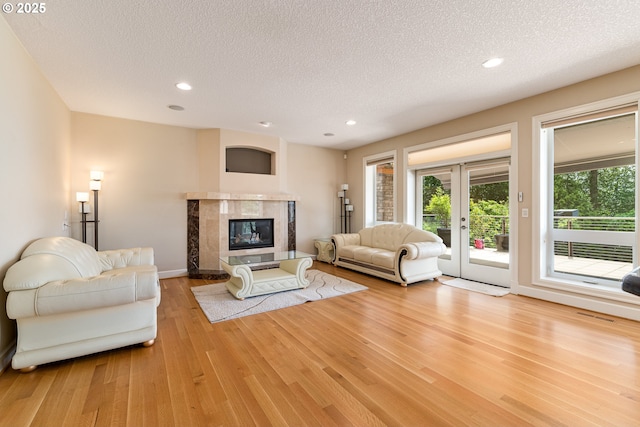 16215 SE Rivershore Dr, Vancouver, WA 98683 - living room featuring wood finished floors, a textured ceiling, a tiled fireplace, recessed lighting, and baseboards