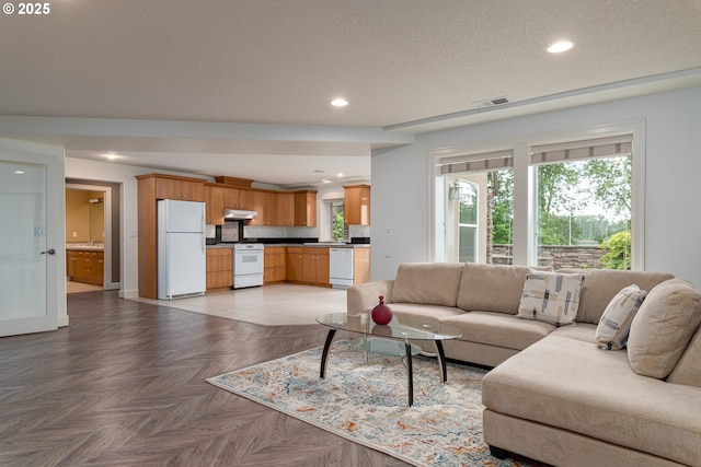 16215 SE Rivershore Dr, Vancouver, WA 98683 - living room featuring a textured ceiling, recessed lighting, and baseboards
