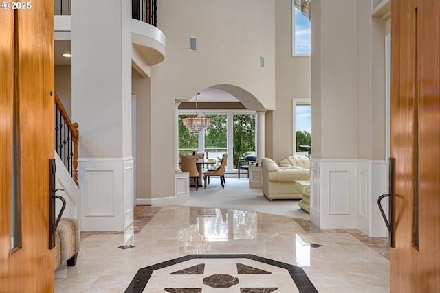 16215 SE Rivershore Dr, Vancouver, WA 98683 - foyer entrance with inlaid floor details, a high ceiling, light marble finish flooring, arched walkways, and a chandelier