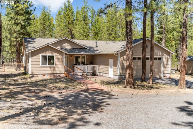 view of front of home with roof with shingles, driveway, an attached garage, a porch, and fence