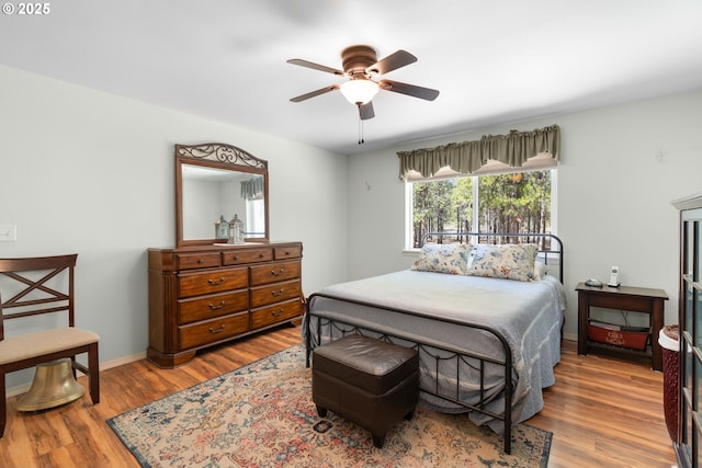 bedroom with wood finished floors, ceiling fan, and baseboards