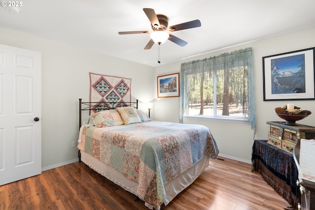 bedroom featuring wood finished floors, baseboards, and ceiling fan