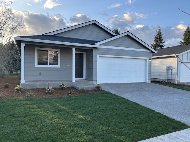 ranch-style house featuring an attached garage, a shingled roof, driveway, and a front yard