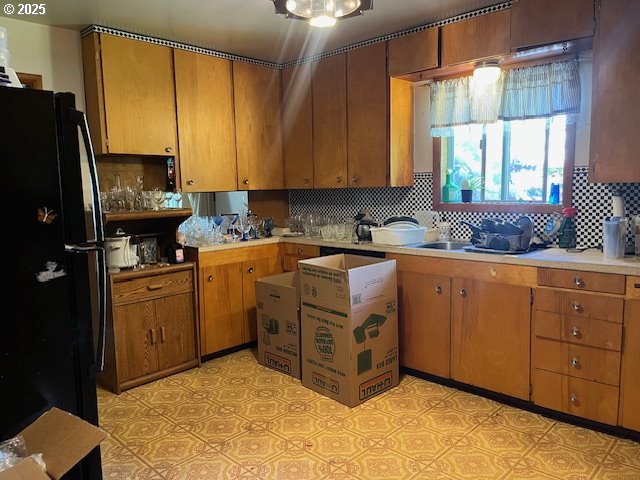 13727 SE Raymond St, Portland, OR 97236 - kitchen featuring freestanding refrigerator, light countertops, backsplash, and brown cabinetry