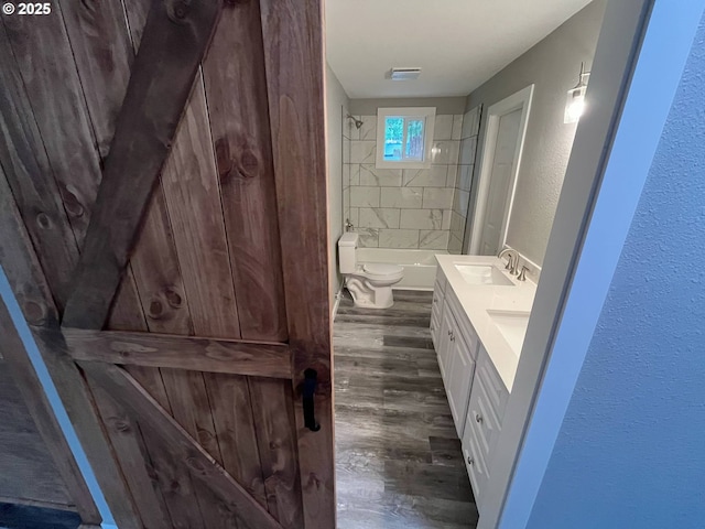 441 NE Johnson St, Myrtle Creek, OR 97457 - bathroom featuring wood finished floors, toilet, double vanity, a textured wall, and shower / tub combination