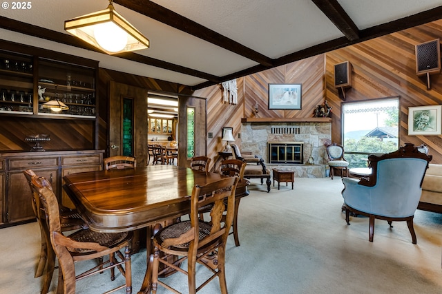 36910 Edgehill Rd, Springfield, OR 97478 - dining space with wooden walls, beamed ceiling, a fireplace, and light colored carpet