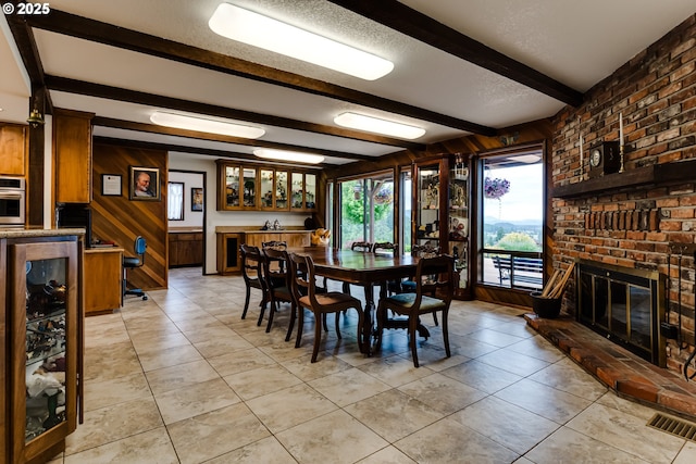 36910 Edgehill Rd, Springfield, OR 97478 - dining area featuring wine cooler, wood walls, beam ceiling, light tile patterned floors, and a fireplace