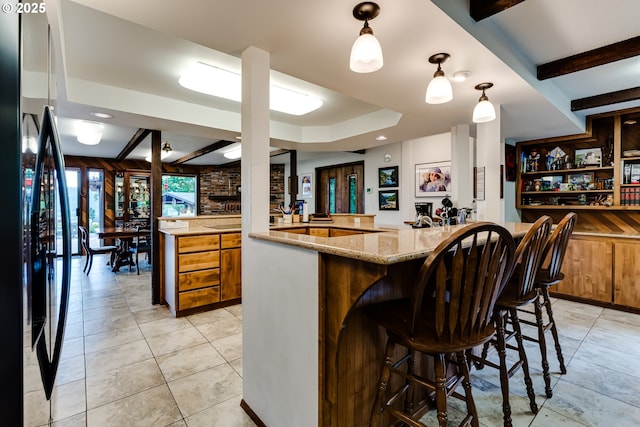 36910 Edgehill Rd, Springfield, OR 97478 - kitchen featuring fridge with ice dispenser, light stone counters, decorative light fixtures, a breakfast bar area, and light tile patterned floors