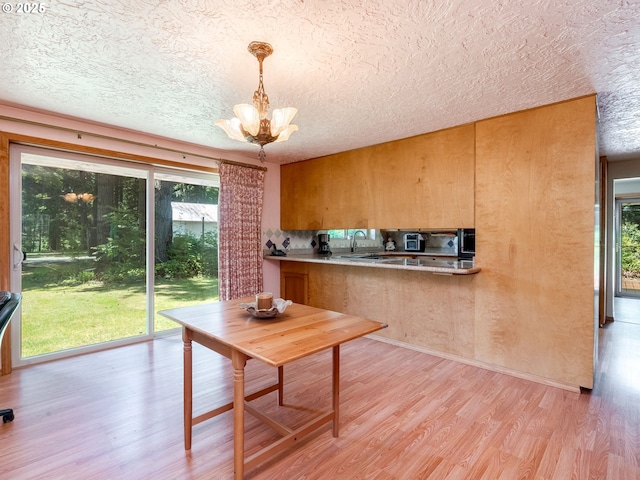 24873 S Beeson Rd, Beavercreek, OR 97004 - dining room featuring a textured ceiling, light wood-type flooring, healthy amount of natural light, and a chandelier