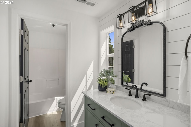 full bathroom with vanity, toilet, wood finished floors, and visible vents