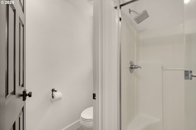 bathroom with a shower stall, toilet, baseboards, and visible vents