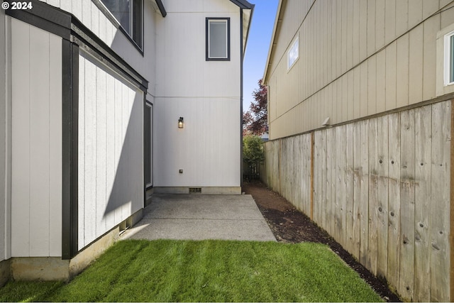 view of property exterior with crawl space, a patio area, a lawn, and fence