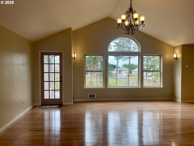 2180 Hayes St, North Bend, OR 97459 - unfurnished dining area with wood finished floors, lofted ceiling, a chandelier, and baseboards