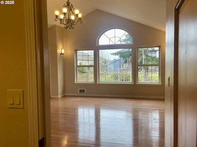 2180 Hayes St, North Bend, OR 97459 - empty room featuring plenty of natural light, light wood-type flooring, vaulted ceiling, and a chandelier