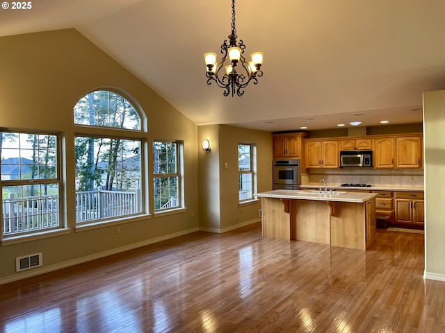 2180 Hayes St, North Bend, OR 97459 - kitchen featuring stainless steel microwave, light countertops, a chandelier, a sink, and wood finished floors