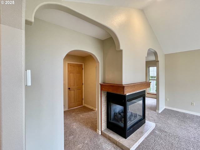 unfurnished living room with lofted ceiling, carpet, and baseboards