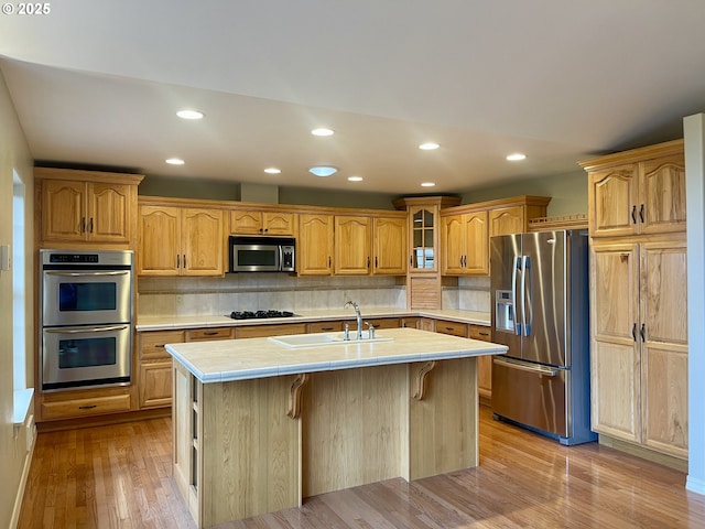 2180 Hayes St, North Bend, OR 97459 - kitchen with appliances with stainless steel finishes, a sink, recessed lighting, light wood-type flooring, and a kitchen island with sink
